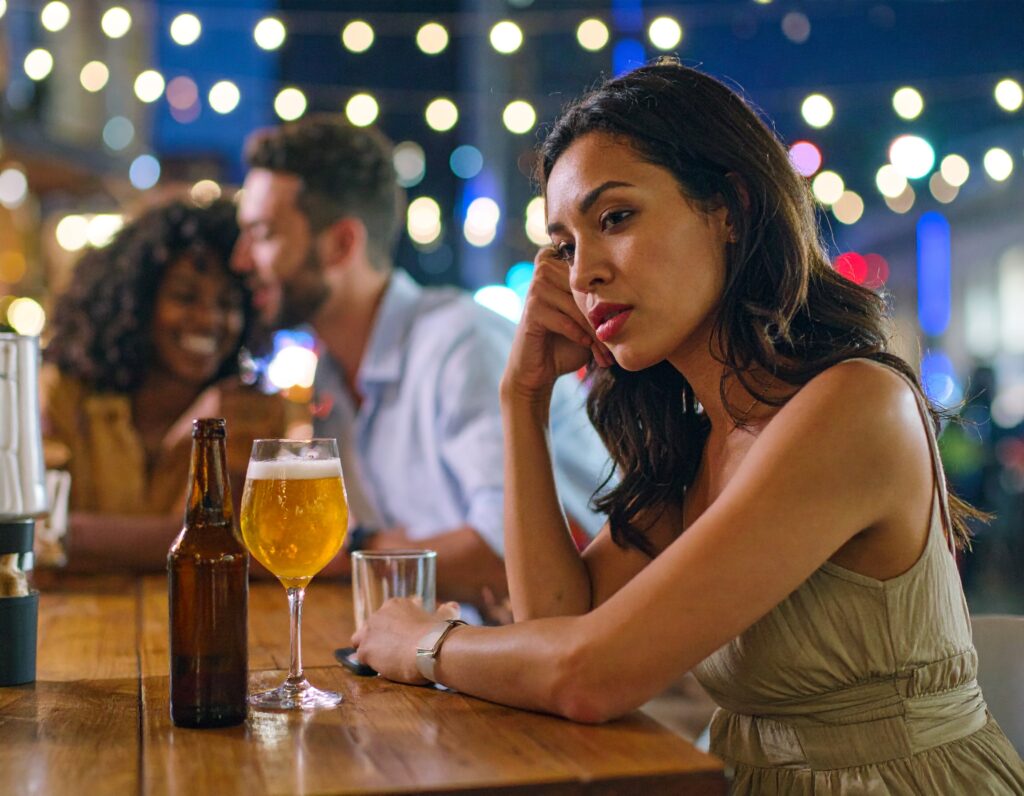 Jeune femme pensive assise à une table de bar