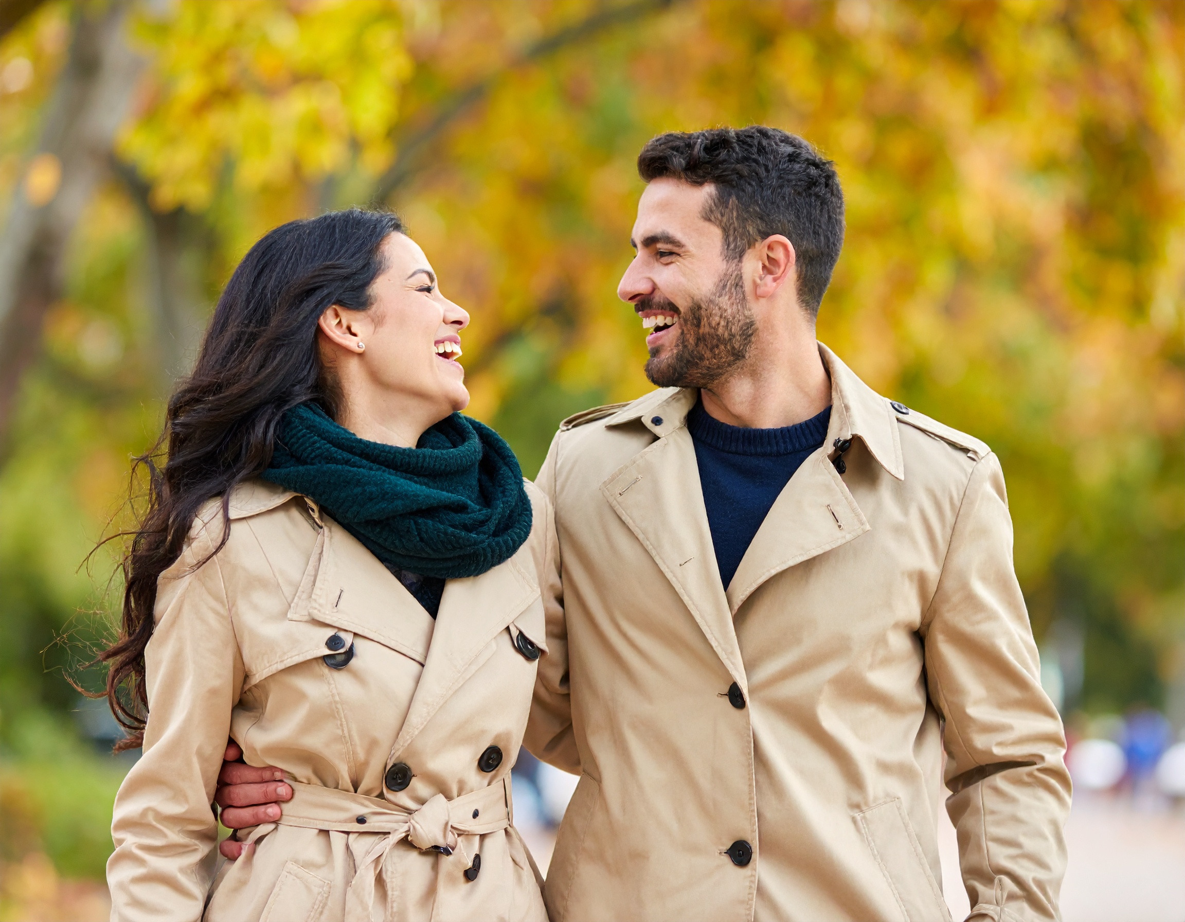 Couple souriant marchant ensemble dans un parc